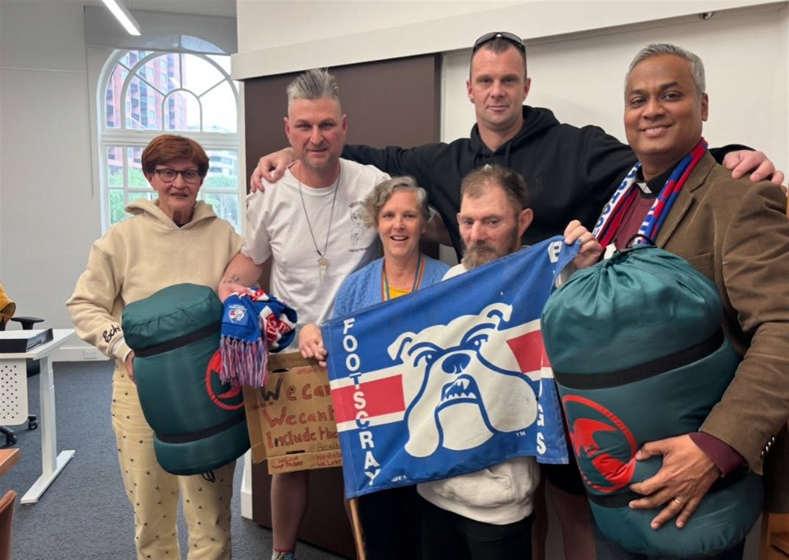 A group of community members holding football-themed gifts