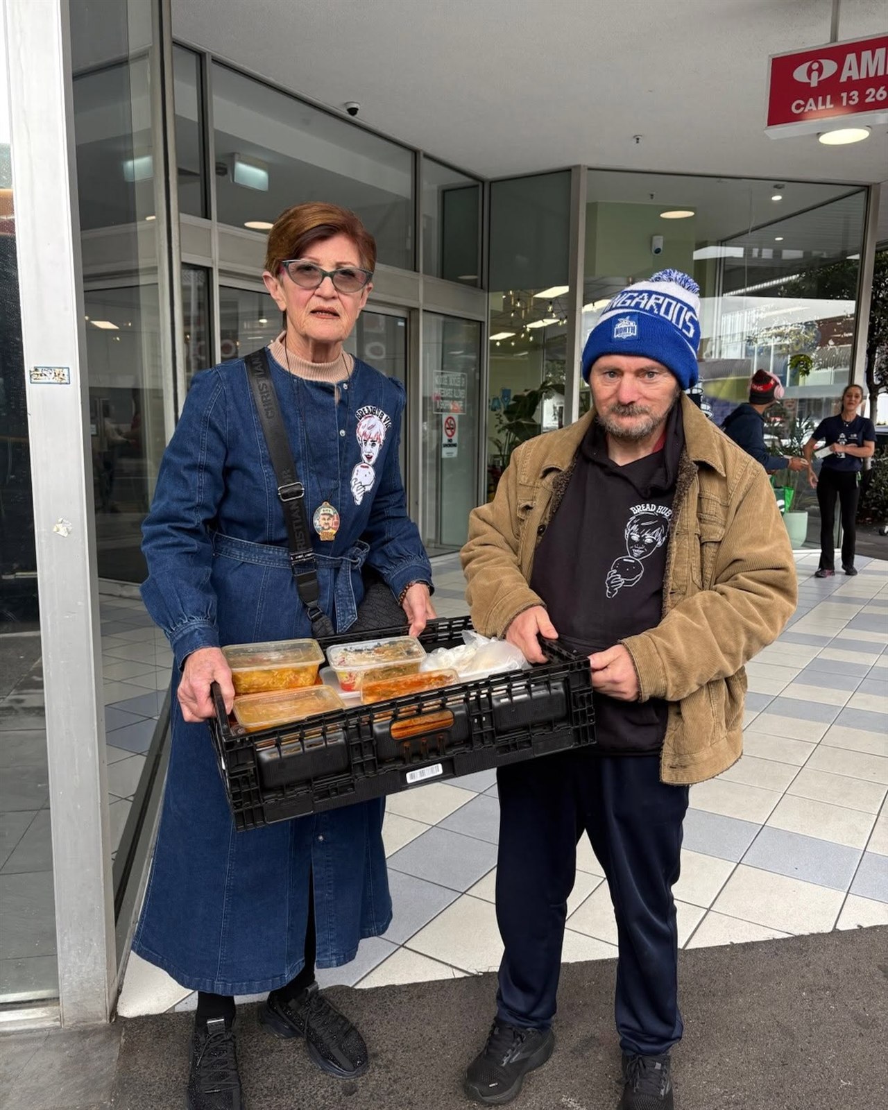 Two Bread Hub Victoria community members holding a crate of food